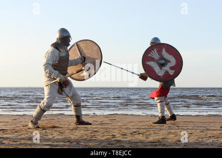 Due medievale guerrieri slavi sono combattimenti con spade e scudi sulla spiaggia Foto Stock