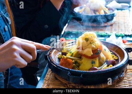 Slow-il pollo cotto con le prugne secche, le mandorle, le cipolle e cosparso di sesamo, tagine marocchino Foto Stock