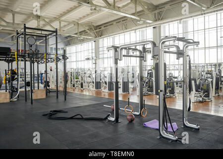 Interno di una moderna palestra con attrezzature. Anello di ginnastica nel centro fitness. Accessori per la formazione nello sport club. Foto Stock