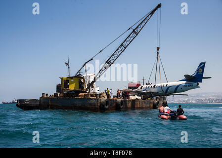 Un decommissionata piccolo aereo passeggeri winched visto nell'acqua durante il progetto. Dismessi velivoli sono winched nell'acqua fuori la città di Saida in Libano come parte di un progetto di conservazione per creare un reef artificiale. Il fondo del mare qui è arido così l idea è quella di fornire i pesci e invertebrati con strutture permanenti per dare loro un posto di razza e rifugio al fine di aumentare i pesci e vita marina stock per la pesca e il turismo. Foto Stock