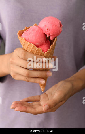 Donna tenendo cono di cialda con fragola deliziosa di gelati, primo piano Foto Stock