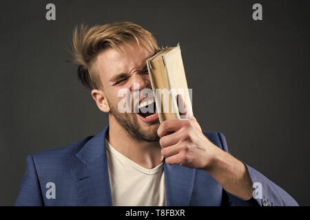 L'uomo faccia sbattere con Libro, motivazione. Imprenditore arrabbiato grida con Libro, conoscenza. La motivazione, potere, successo. La conoscenza, l'informazione, la sapienza education learning studiare letteratura libreria di lettura Foto Stock