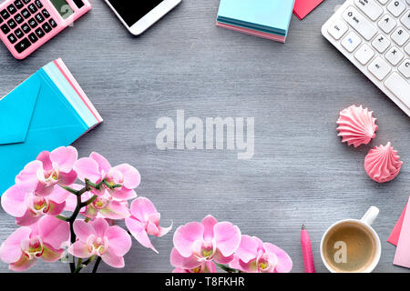 Celebrazione di pianificazione: telefono cellulare tastiera, caffè e invitaiton carte con orchidee su grigio tavolo in legno Foto Stock