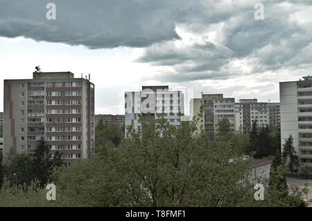 Vista deprimente di brutto edificio comunista blocchi (panelak) in un giorno nuvoloso a Praga su una media di edifici in cemento station wagon Foto Stock