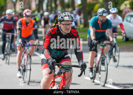 Piloti in Birmingham Velo 100 miglio giro in bicicletta, corsa attraverso il frondoso sobborgo di Birmingham di Harborne verso la linea di finitura Foto Stock