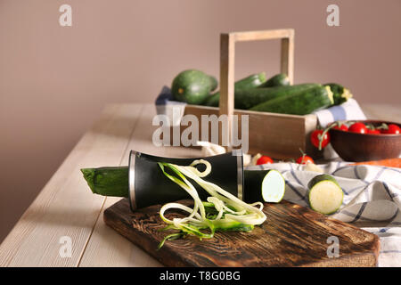 Zucchine fresche spaghetti con grattugia a spirale sul tavolo di legno Foto Stock