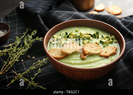 Gustosa zuppa di zucchine con crostini nella ciotola sul tavolo Foto Stock