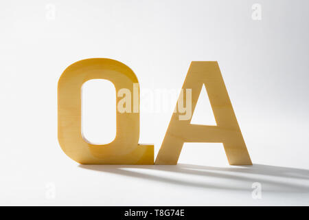 Alfabeto di legno Q un ombra e riflessione. Domande e risposte. Foto Stock