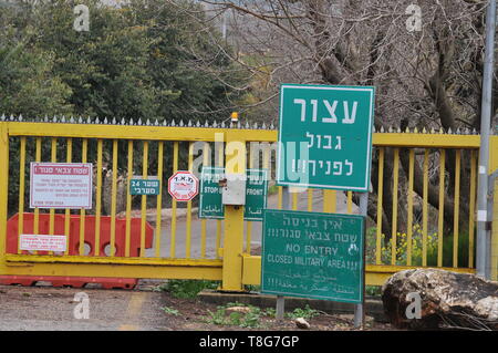 Israele, Galilea superiore il recinto buono di frontiera tra Israele e il Libano nei pressi di Metula una lettura del segno di confine di arresto di fronte a voi in inglese, EB Foto Stock