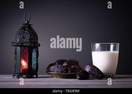 Il Ramadan il cibo e le bevande del concetto. Il Ramadan lanterna con latte, date di frutta sul tavolo di legno dello sfondo. Foto Stock