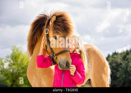 Cavallo islandese. Smooching ragazza con un pinto castrazione. Austria Foto Stock