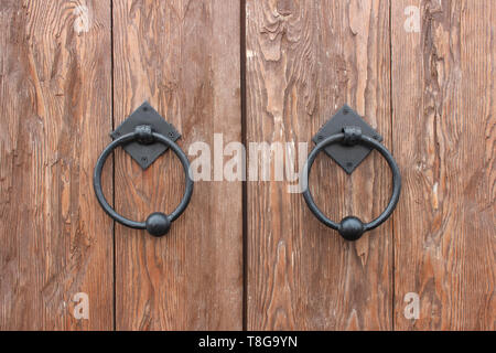 Porte in legno di quercia con letti in ferro battuto con maniglie a forma di anelli Foto Stock