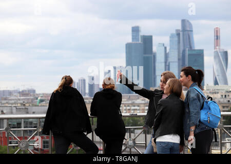 Mosca, Russia - Maggio 2019: le fanciulle felici turisti fanno un selfie con lo smartphone sulla città di Mosca grattacieli sullo sfondo. Panorama di Mosca Foto Stock