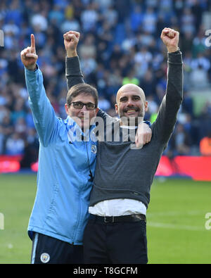 BRIGHTON, Inghilterra - 12 Maggio: Manchester City manager Pep Guardiola festeggia vincendo la Premier League titolo a tempo pieno con i suoi compagni di squadra durante il match di Premier League tra Brighton & Hove Albion e il Manchester City in American Express Community Stadium il 12 maggio 2019 in Brighton, Regno Unito. (MB Media) Foto Stock