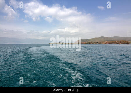 Nelle acque del lago di Ohrid sotto un cielo nuvoloso contro lo sfondo delle montagne colline sopra la città. Foto Stock