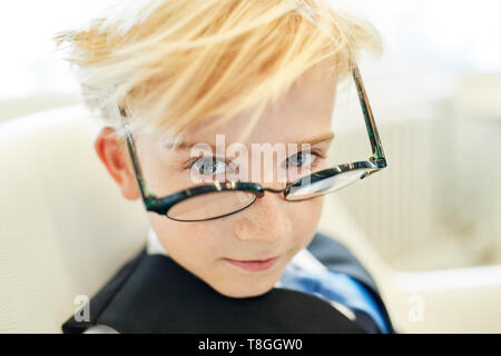 Ragazzo con gli occhiali come una smart allievo o studente o imprenditore in ufficio Foto Stock