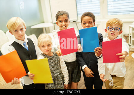 I bambini come la gente di affari con colorati scivola fare un gioco di teambuilding Foto Stock