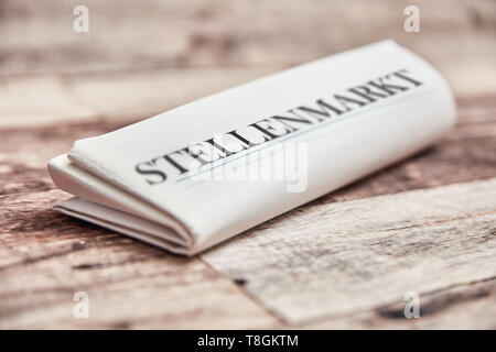 Parola tedesca "tellenmarkt' (mercato del lavoro) con borsa lavoro nel giornale su legno Foto Stock