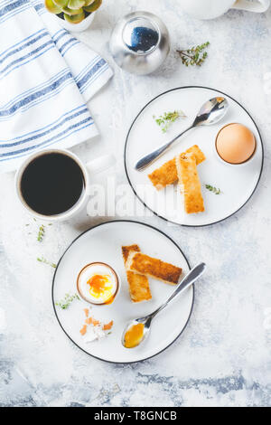 Uova sode per la colazione con pane tostato e la tazza di caffè in background. Vista dall'alto. Foto Stock