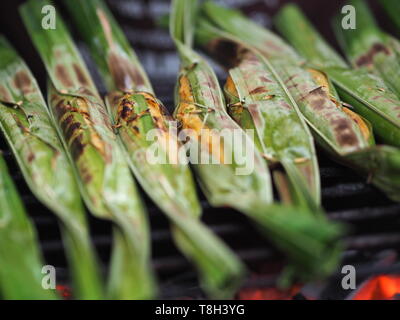 La frittura di pesce palline di pasta o torta di pesce in foglie di banano grill sulla griglia in acciaio Foto Stock