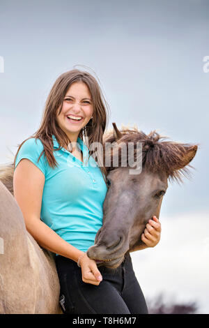Cavallo islandese. Giovane donna smooching con dun mare. Austria Foto Stock