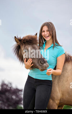 Cavallo islandese. Giovane donna smooching con dun mare. Austria Foto Stock