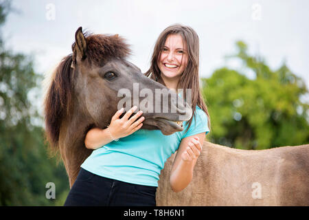 Cavallo islandese. Giovane donna smooching con dun mare. Austria Foto Stock