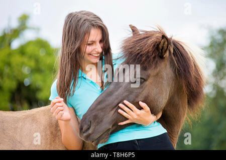 Cavallo islandese. Giovane donna smooching con dun mare. Austria Foto Stock