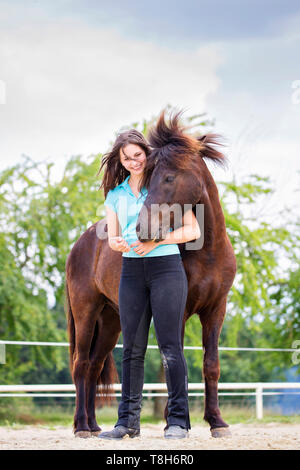 Cavallo islandese. Giovane donna smooching con nero castrazione. Austria Foto Stock