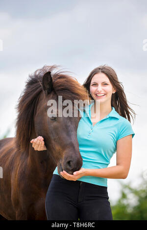 Cavallo islandese. Giovane donna smooching con nero castrazione. Austria Foto Stock