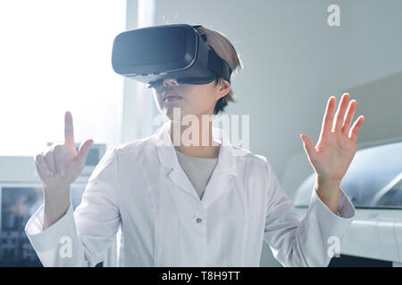 Signora scienziato modifica le informazioni sulla ricerca tramite simulatore VR Foto Stock