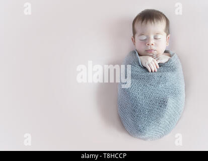 Ragazza neonata slepping avvolgimento in un blanket di grigio Foto Stock