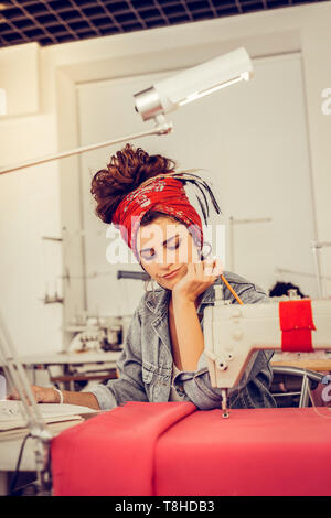 Designer guardando i suoi schizzi e pensare al loro miglioramento. Foto Stock