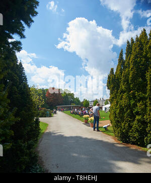 Una folla di gente che godendo il sole a Burnby Hall Gardens, Pocklington, East Riding of Yorkshire, Inghilterra, Regno Unito, GB. Foto Stock