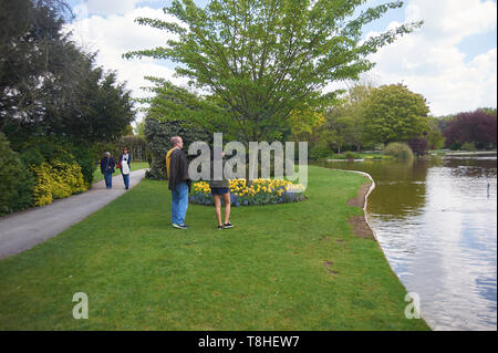 Una folla di gente che godendo il sole a Burnby Hall Gardens, Pocklington, East Riding of Yorkshire, Inghilterra, Regno Unito, GB. Foto Stock