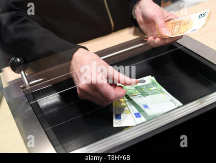 Garmisch Partenkirchen, Germania. Il 10 maggio, 2019. Una donna può essere pagato in contanti in una filiale di banca al contatore. Il BGH chiarisce se le banche possono raccogliere una tassa per i depositi e i prelievi presso il contatore. Credito: Angelika Warmuth/dpa/Alamy Live News Foto Stock