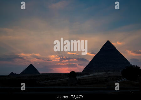 Silhouette di piramidi al tramonto, sito di Giza vicino al Cairo, Egitto Foto Stock