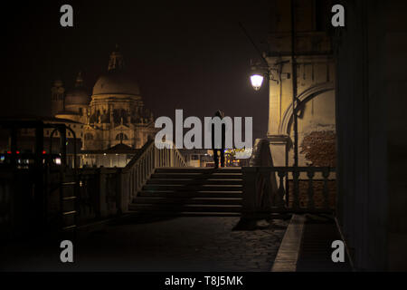 Silhouette di un uomo a piedi attraverso le strade di notte, Venezia, Veneto, Italia Foto Stock