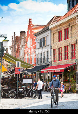 Piccola strada secondaria, nel centro storico di bruges, gente a piedi, anziano uomo in bicicletta godendo di un lento giro attraverso strade acciottolate, brugge, Belgio. Foto Stock