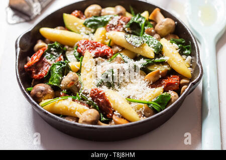 Gli gnocchi di patate, spinaci, pomodori secchi e zucchine in salsa di formaggio Foto Stock