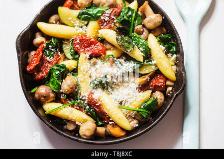 Gli gnocchi di patate, spinaci, pomodori secchi e zucchine in salsa di formaggio Foto Stock