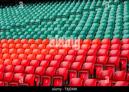 Rosso e verde sedili in plastica in un vuoto, grande stadio sportivo Foto Stock