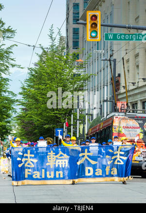 Falun Dafa, noto anche come Falun Gong, professionisti nella terra divina Marching Band Marzo in sfilata per le strade del centro cittadino di Vancouver. Foto Stock
