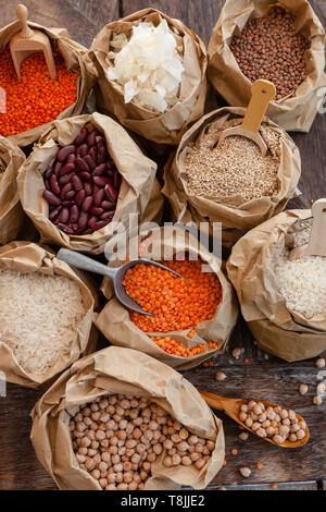 Varietà di legumi secchi e cereali in piccoli sacchetti di carta Foto Stock