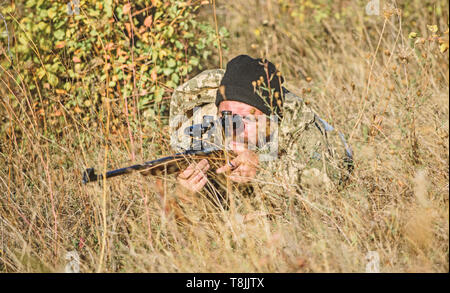 Abilità di caccia e di apparecchiature di arma. Come ruotare la caccia in hobby. Uomo Barbuto hunter. Forze armate. Il camuffamento. Uniforme militare di moda. Uomo cacciatore con fucile pistola. Boot camp. Attrezzature militari. Foto Stock