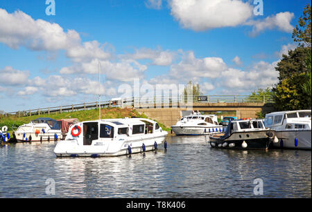 Una vista di incrociatori del motore sul fiume Ant su Norfolk Broads negoziando la A1062 ponte stradale a Ludham, Norfolk, Inghilterra, Regno Unito, Europa. Foto Stock