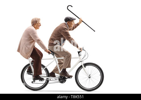 A piena lunghezza shot di un senior l uomo e la donna in sella ad una bicicletta in tandem e agitando con un bastone da passeggio isolati su sfondo bianco Foto Stock