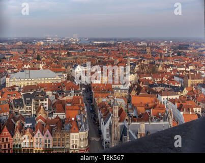 Bruges fantastico skyline della città con tetti di tegole rosse e numerose chiese' torri nella soleggiata giornata invernale. Vista di Bruges paesaggio urbano medievale dalla parte superiore Foto Stock