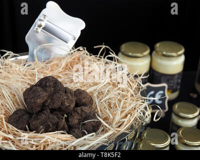 Pila di tartufo intero in un mercato alimentare con un'affettatrice Foto Stock