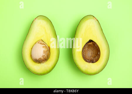 Fette di Avocado sullo sfondo verde Foto Stock